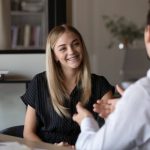 Happy intern listening to mentor, consulting advisor, talking to supervisor, smiling, laughing. Job candidate meeting with employer for interview, discussing vacancy, making good first impression